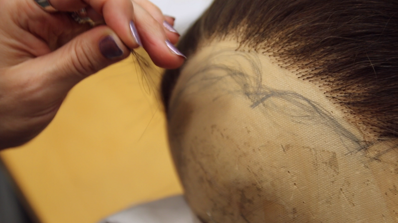 Jurga knots individual strands of hair.
